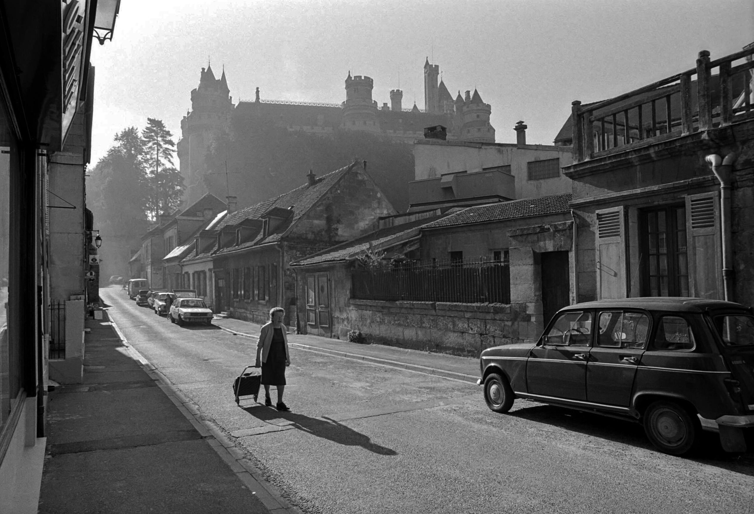 A sleek black expandable suitcase on a cobblestone street