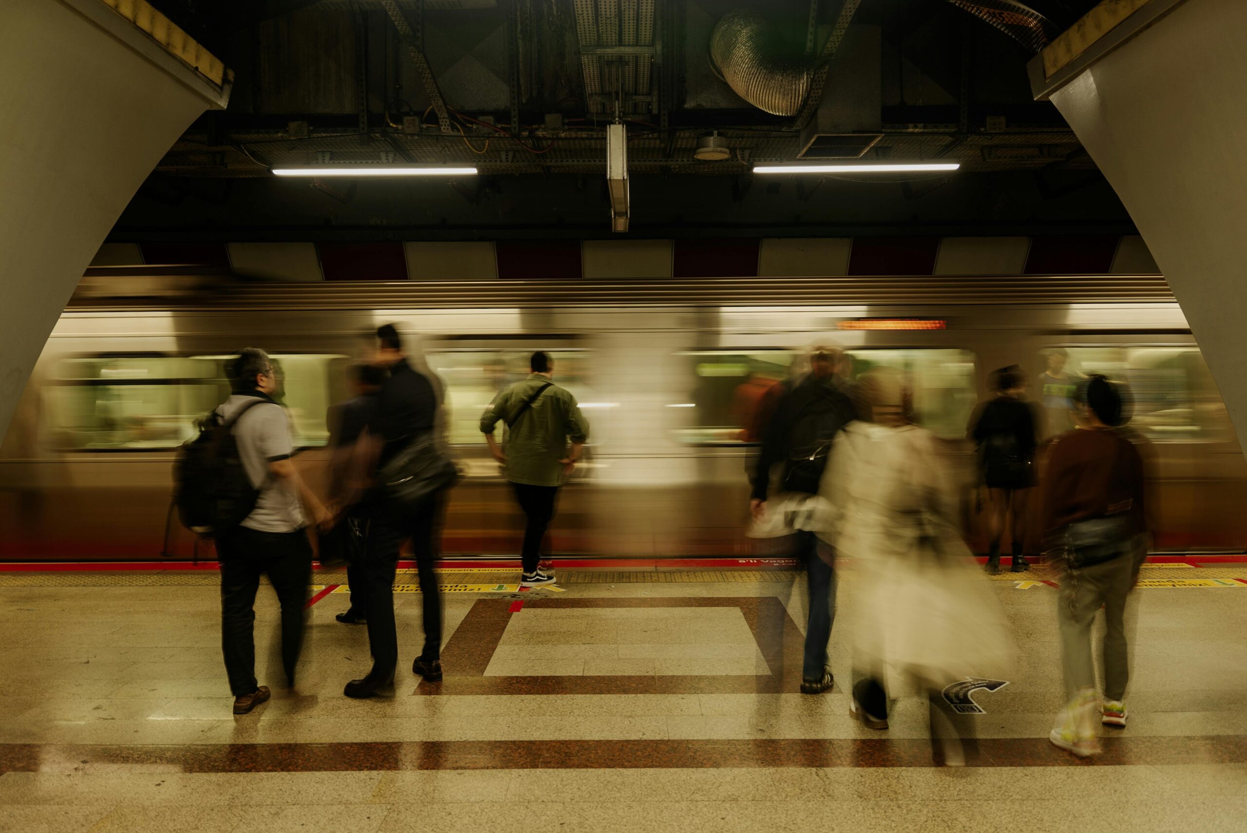 a traveler happily pulling her expandable luggage at a busy train station