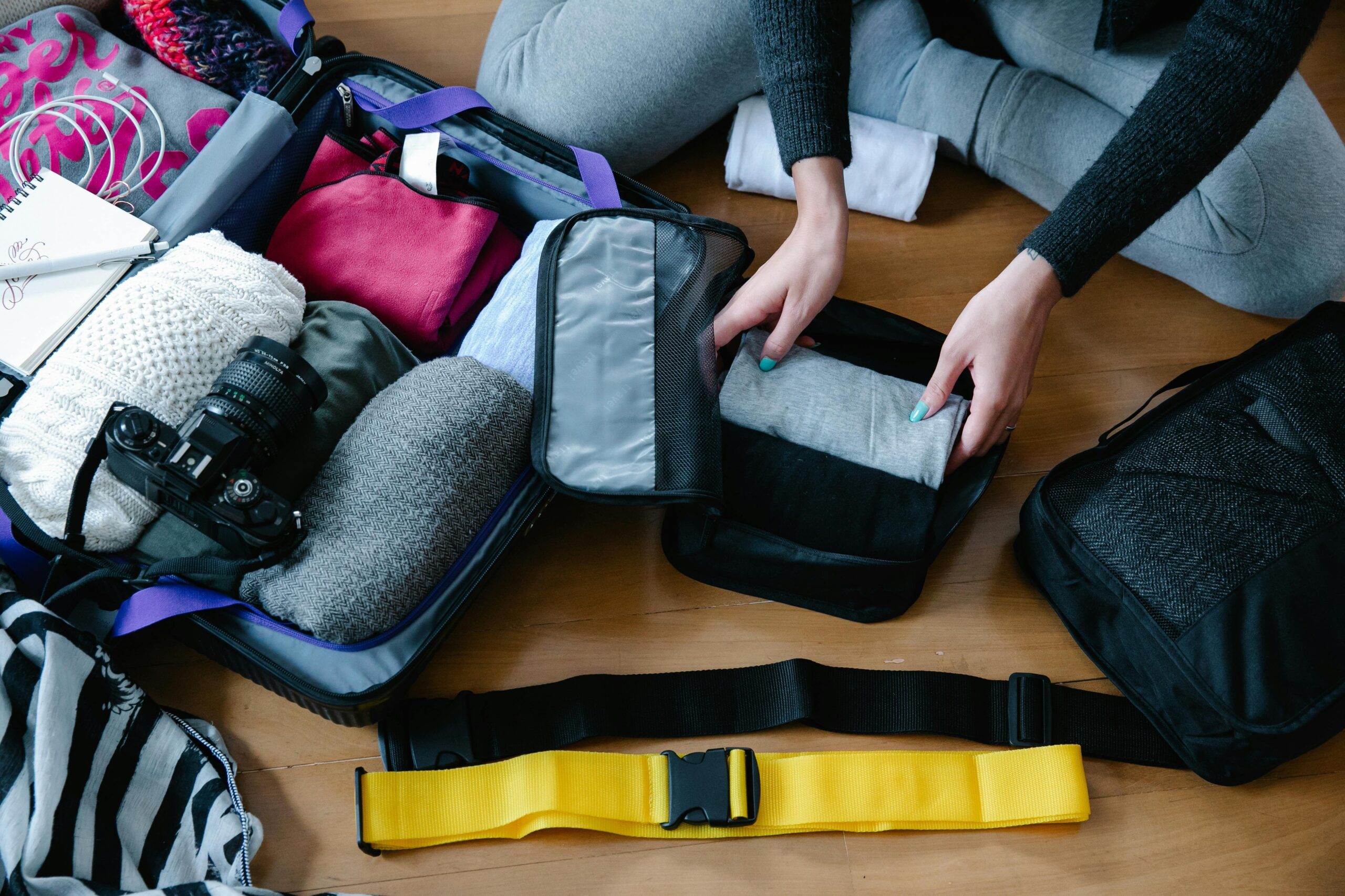 Luggage opened up showing neatly rolled clothes and packing cubes