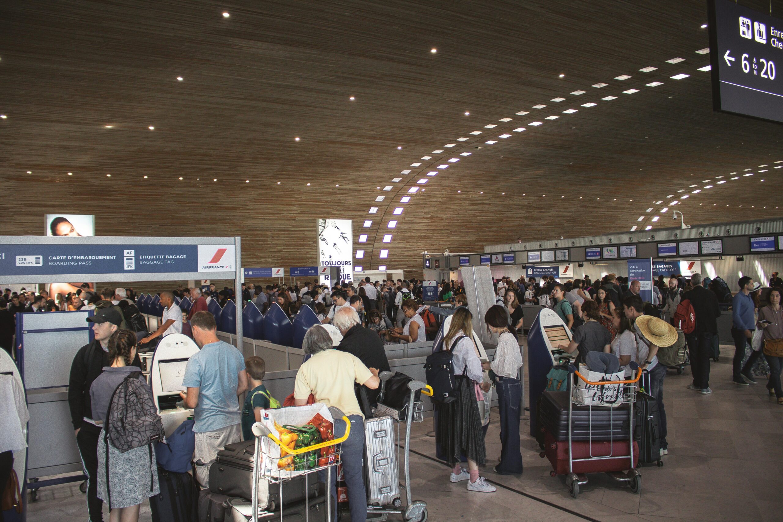 Person struggling with overstuffed suitcase at airport check-in