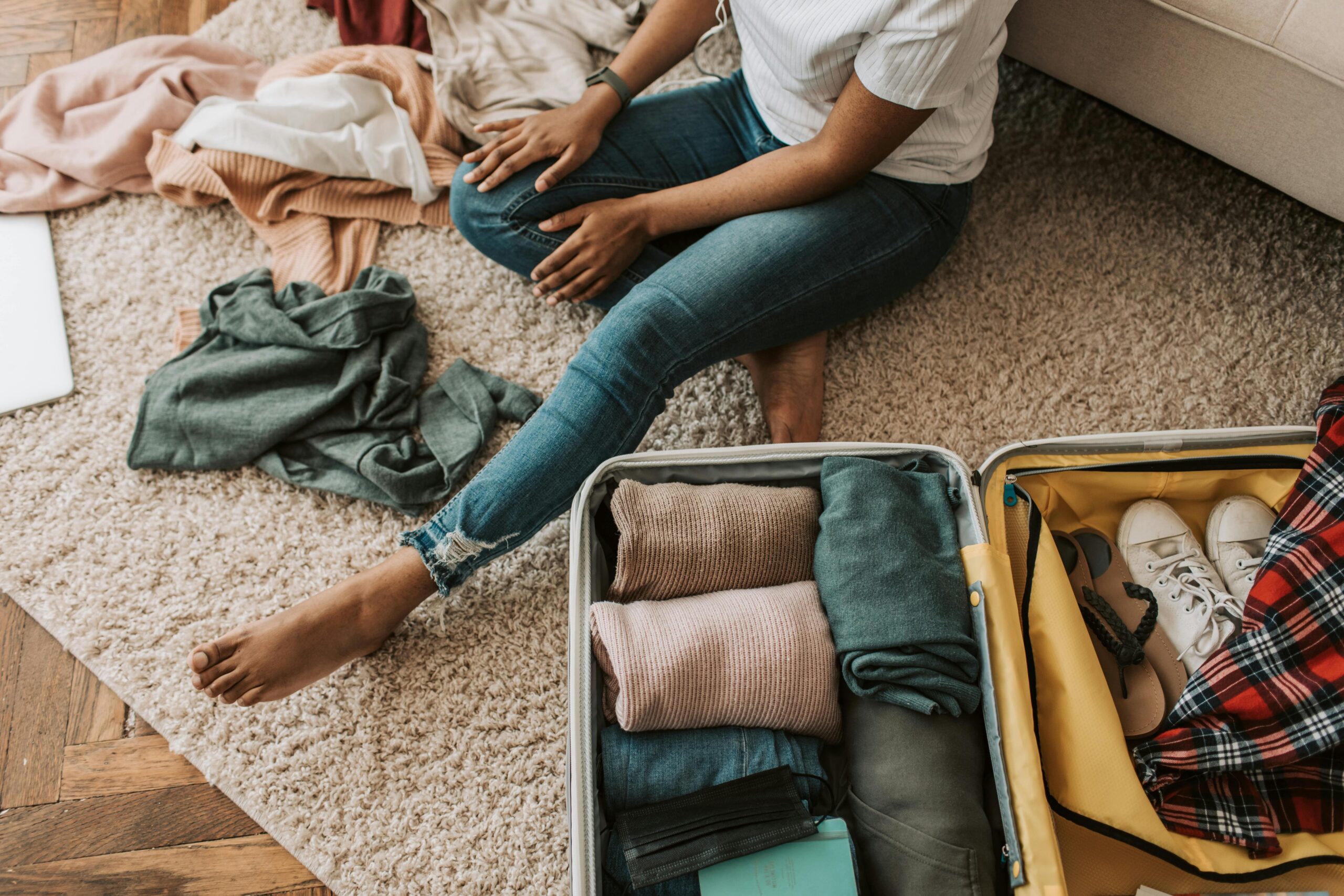 An overstuffed suitcase bursting with clothes, shoes, and souvenirs