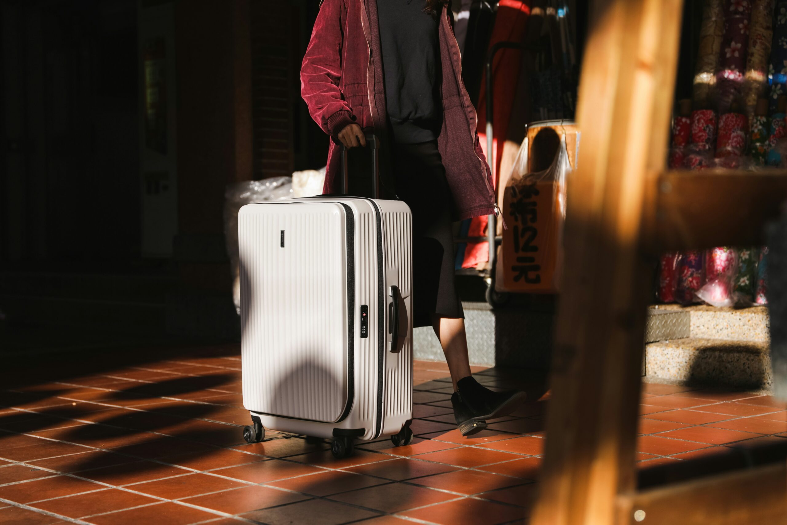 Traveler smiling next to fully expanded suitcase