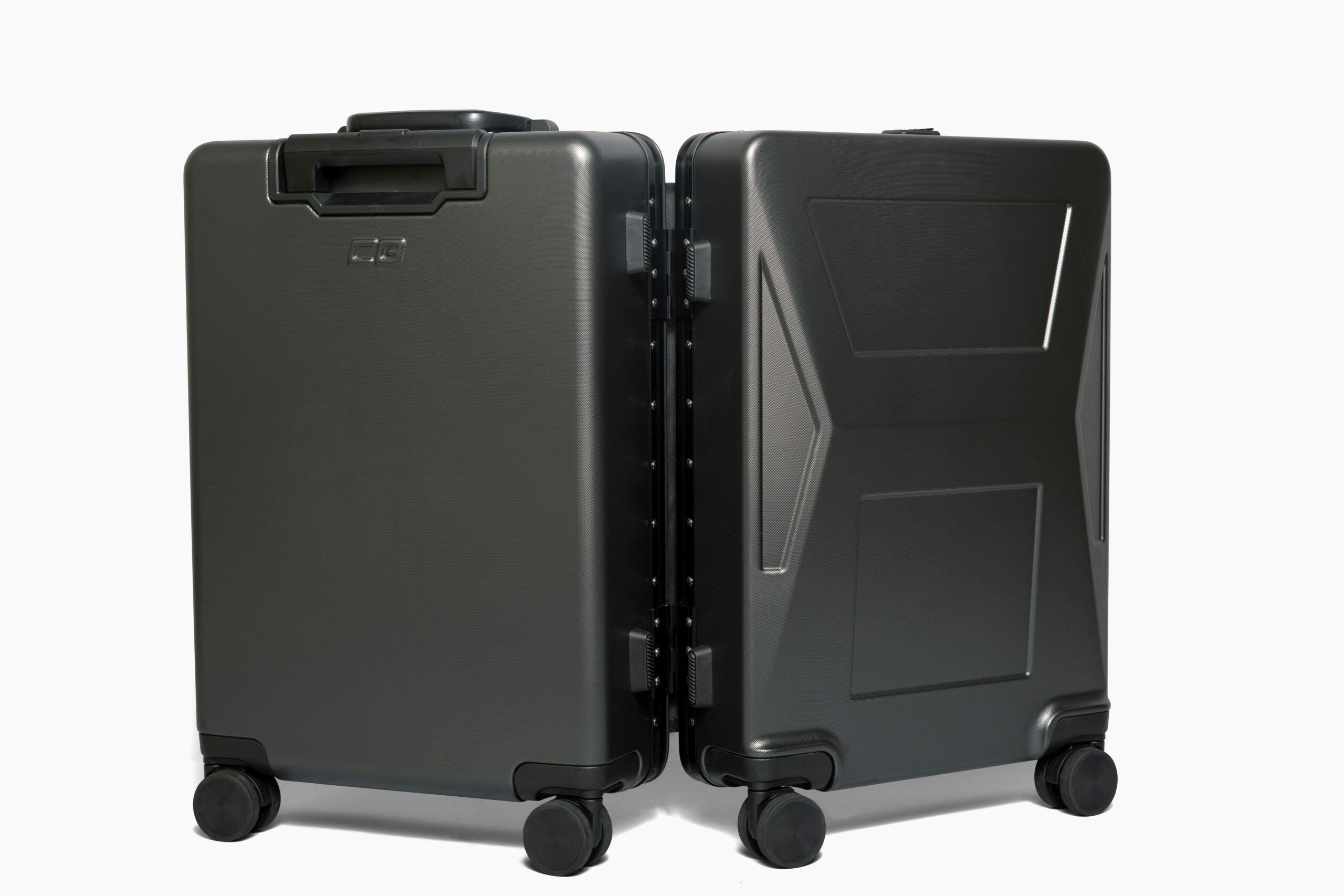 A modern black expandable space saver suitcase lying open on a bed with clothes neatly packed inside.
