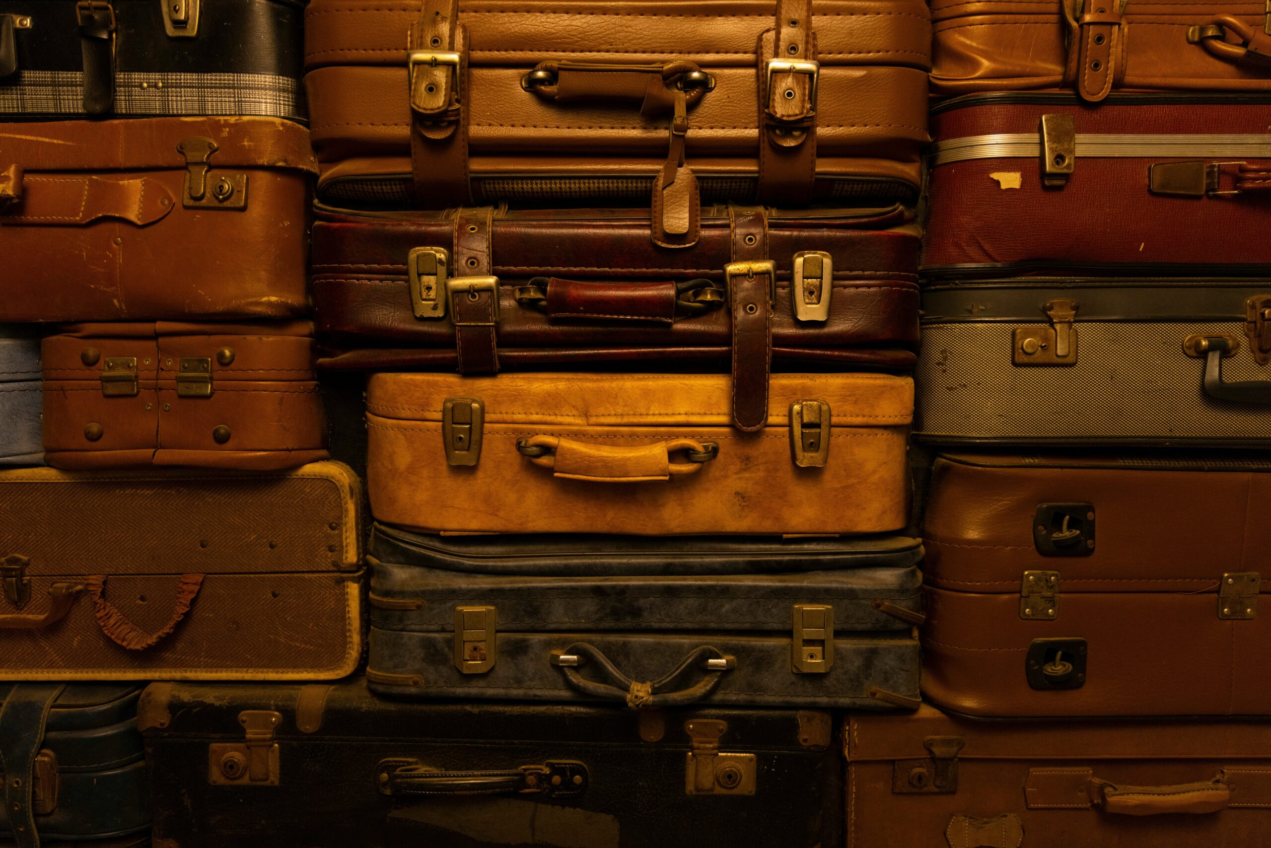 An overstuffed suitcase struggling to close at an airport.
