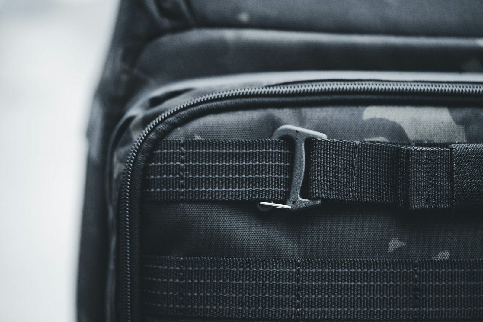 A traveler struggling to adjust their oversized suitcase at airport security.