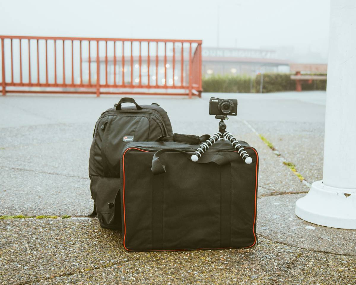 A sleek black suitcase partially expanded showing additional compartment