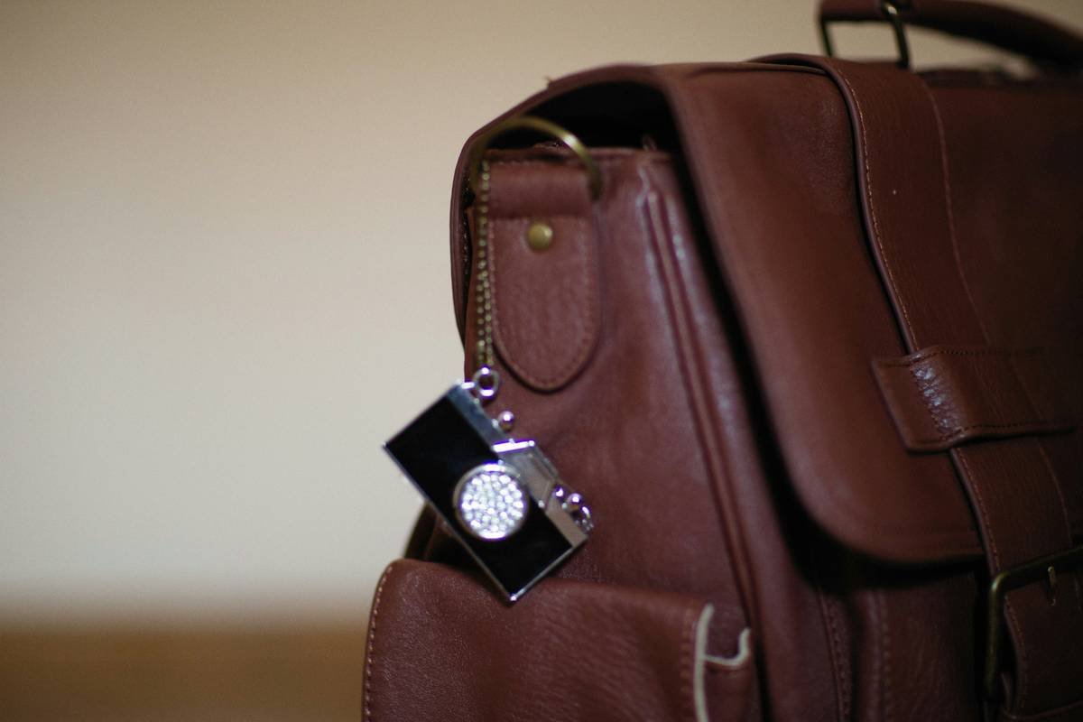 A sleek black travel flex expandable tote with its expansion zipper open, showing increased capacity.