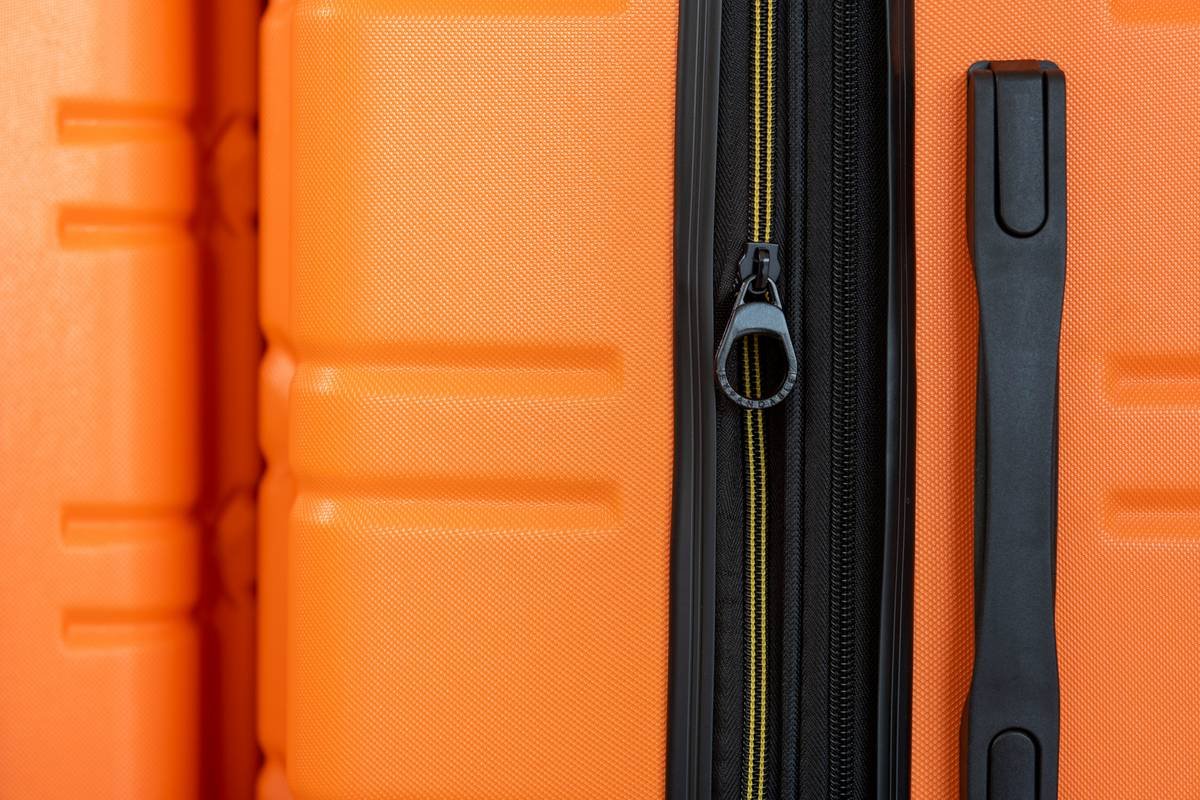 Diagram showing cross-section of expandable luggage with built-in shelves separating clothing, shoes, and accessories
