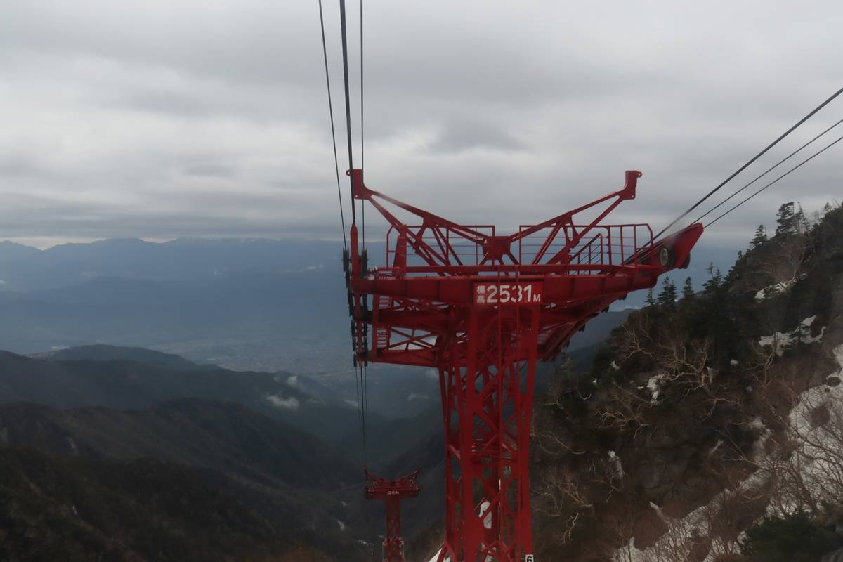 a red ski lift with a mountain in the background