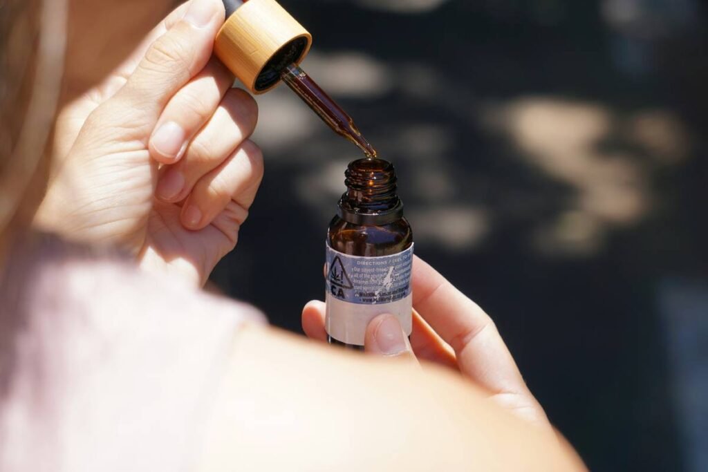 person holding brown glass bottle