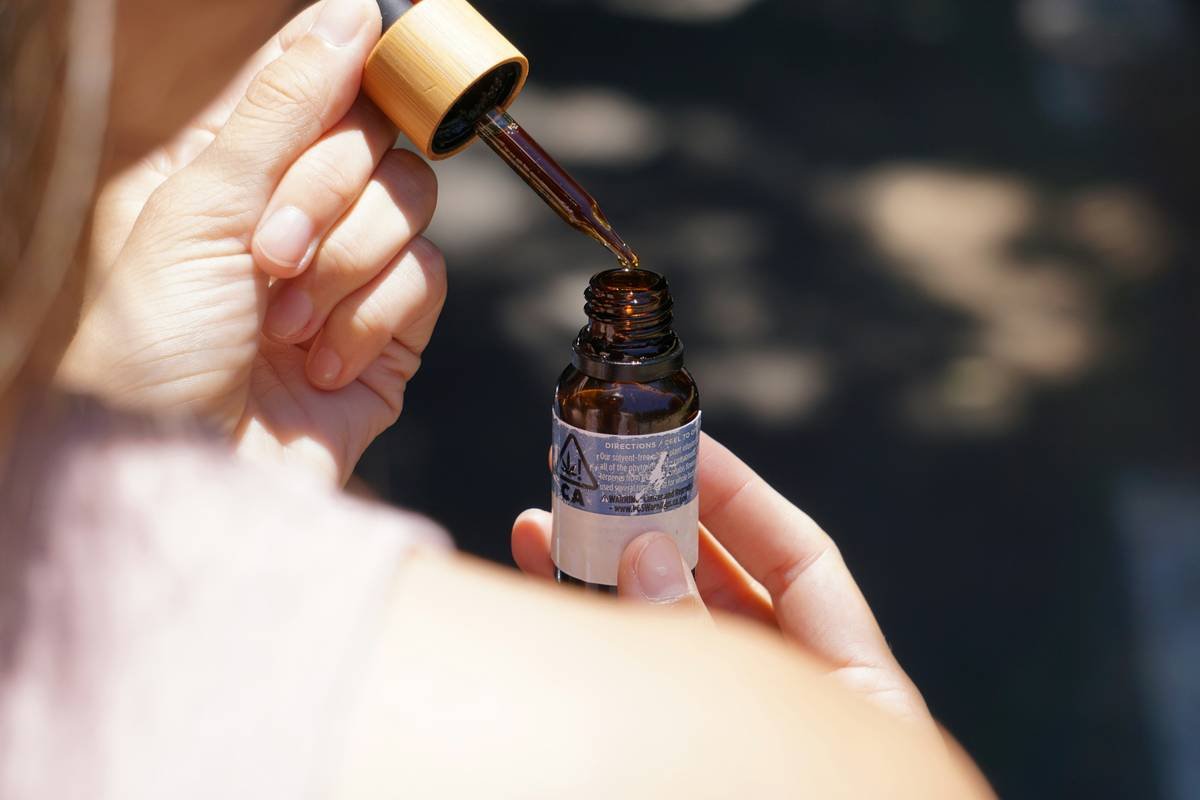 person holding brown glass bottle