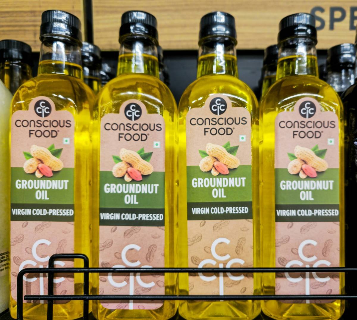 Photograph of groundnut oil bottles arranged on a shelf. Groundnut oil, also known as peanut oil, is widely used in cooking for its high smoke point and nutty flavor. Popular in Indian, Asian, and African cuisines, it is valued for frying, sautéing, and traditional recipes. The image highlights the golden tone of the oil and the product packaging, suitable for food, health, and retail contexts.