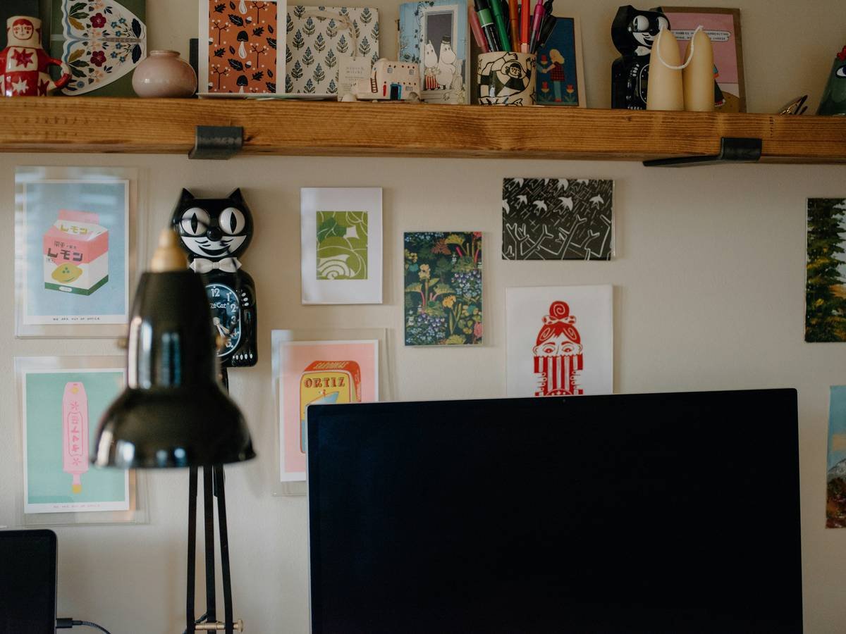 Wall art and a black desk lamp in a room.