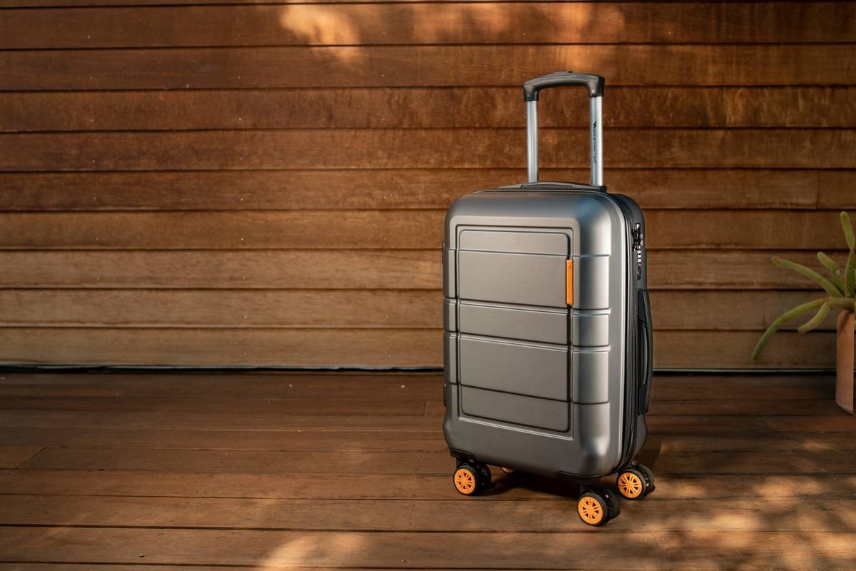 Traveler effortlessly zipping open accessories expandable luggage versatile suitcase at airport